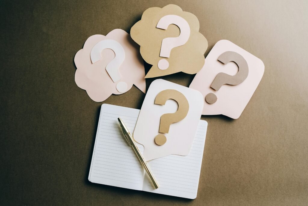 pexels photo 5428830 5428830 2 Flat lay of question mark paper crafts on a notebook, symbolizing questions and ideas.
